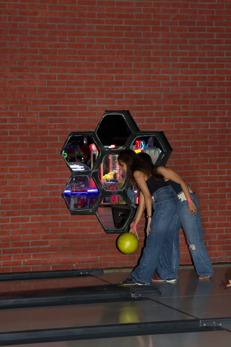 Guests bowling beside the arcade wall